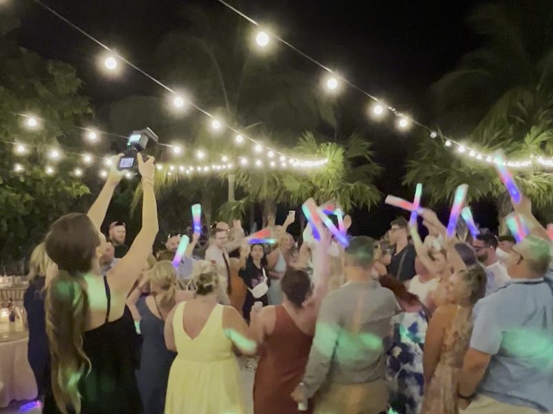 Packed dance floor under string lights at night